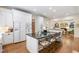 Spacious kitchen showcasing a large island with seating, white cabinets, stainless appliances and hardwood floors at 205 Buncombe St, Raleigh, NC 27609