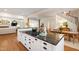 Open-concept kitchen features granite counters, a cooktop island, and flows into the dining and living areas at 205 Buncombe St, Raleigh, NC 27609
