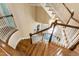 Elegant staircase with hardwood steps and white railings leading to the upper level, lit by hanging fixture at 205 Buncombe St, Raleigh, NC 27609