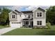 Charming two-story home featuring a two-car garage, white siding, and professionally landscaped yard at 207 Yellow River Way, Garner, NC 27529