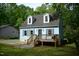Charming light blue home featuring a cozy front porch, dormer windows, and a lush green surrounding landscape at 2315 George Anderson Dr, Hillsborough, NC 27278