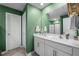 Bright bathroom featuring double vanity with white cabinets, white countertops, and a large mirror at 2415 Ivy Knoll Dr, Mebane, NC 27302