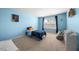 Bright bedroom with blue walls, carpet flooring, a large window, and a space-themed bedspread at 2415 Ivy Knoll Dr, Mebane, NC 27302