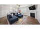 Bright living room with a fireplace, TV, stylish blue sectional, and open layout into the kitchen at 2415 Ivy Knoll Dr, Mebane, NC 27302
