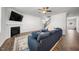 Comfortable living room with a fireplace, TV, cozy blue sectional, and open access to the entryway at 2415 Ivy Knoll Dr, Mebane, NC 27302