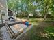 Gathering-friendly backyard with a sandbox, patio, and lush greenery, ideal for outdoor fun at 2540 Beech Gap Ct, Raleigh, NC 27603