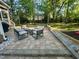 Outdoor patio featuring a stone fire pit, stylish seating, and a lush green lawn and mature trees at 2540 Beech Gap Ct, Raleigh, NC 27603