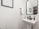 Modern half bathroom featuring a pedestal sink, vanity mirror and neutral decor at 2540 Beech Gap Ct, Raleigh, NC 27603