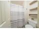 Cozy bathroom includes a tiled shower, toilet and rustic wooden shelves at 3004 Red Cir, Willow Springs, NC 27592