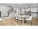 Bright dining area featuring a modern table with seating and pendant lights; open concept to kitchen and stairs at 3018 White Rail Dr, Fuquay Varina, NC 27526