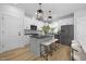 Modern kitchen featuring white cabinets, stainless steel appliances, gray island with seating and pendant lighting at 3018 White Rail Dr, Fuquay Varina, NC 27526