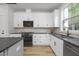A well-equipped kitchen with white cabinets, stainless steel appliances and elegant countertops at 3018 White Rail Dr, Fuquay Varina, NC 27526