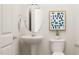 Stylish powder room featuring a pedestal sink, round mirror, and modern accents at 334 Carolina Springs Blvd, Apex, NC 27539