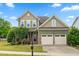 Charming two-story home featuring a two-car garage, stone accents, and a well-manicured lawn at 364 Springtime Fields Ln, Wake Forest, NC 27587