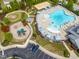 Aerial view of community pool featuring chairs and umbrellas with a playground in the distance at 364 Springtime Fields Ln, Wake Forest, NC 27587