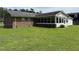 Exterior view of the home's backyard featuring a well-maintained lawn and sunroom at 405 Taylor Dr, Rocky Mount, NC 27803