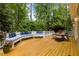 Outdoor living space featuring a wood deck with built-in seating and dining area surrounded by mature trees at 406 Bakewell Ct, Wake Forest, NC 27587