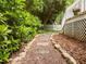 Stone path leading through a lush garden with mature trees and landscaping in the backyard at 406 Bakewell Ct, Wake Forest, NC 27587