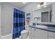 Well-lit bathroom featuring a vanity, toilet, and shower with a blue curtain at 406 Bakewell Ct, Wake Forest, NC 27587