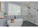 Modern bathroom with a freestanding tub and a glass-enclosed shower at 406 Bakewell Ct, Wake Forest, NC 27587