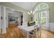 Sun-filled dining room featuring hardwood floors, a chandelier, and an arched window with backyard views at 406 Bakewell Ct, Wake Forest, NC 27587