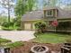 Home exterior showcasing a spacious driveway, two-car garage, lush landscaping, and lovely architectural details at 406 Bakewell Ct, Wake Forest, NC 27587