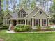 Charming home exterior featuring a well-manicured lawn, lush landscaping, and inviting front porch at 406 Bakewell Ct, Wake Forest, NC 27587