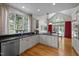 Bright kitchen with stainless appliances, granite countertops, cabinetry, and a backyard patio view at 406 Bakewell Ct, Wake Forest, NC 27587