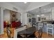 Open-concept kitchen and dining area features stainless appliances and views of the living room with stone fireplace at 406 Bakewell Ct, Wake Forest, NC 27587