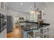 Well-lit kitchen features stainless steel appliances, granite countertops, breakfast bar, and access to the dining area at 406 Bakewell Ct, Wake Forest, NC 27587