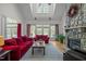 Spacious living room with high ceilings, stone fireplace, large windows, and comfortable red sofas at 406 Bakewell Ct, Wake Forest, NC 27587