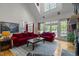 Bright living room featuring a fireplace, hardwood floors, red sofas, and lots of natural light at 406 Bakewell Ct, Wake Forest, NC 27587