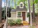 Close up of quaint backyard playhouse with windows, a decorative awning, and covered porch at 406 Bakewell Ct, Wake Forest, NC 27587