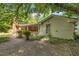 Exterior view of a home featuring a covered patio and a partially visible brick facade, set against a backdrop of lush greenery at 424 Raleigh View Rd, Raleigh, NC 27610