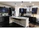 Modern kitchen featuring dark cabinets, a stainless steel refrigerator, and a granite countertop island with seating at 428 Parlier Dr, Apex, NC 27523