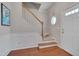 Welcoming foyer with staircase, hardwood floors, wainscoting, and a charming round window, creating an inviting entrance at 4306 Brynwood Ave, Durham, NC 27713