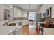 Bright kitchen boasting stainless steel appliances, white cabinetry, mosaic tile backsplash, and hardwood floors at 4306 Brynwood Ave, Durham, NC 27713
