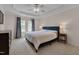 Spacious main bedroom with a ceiling fan, tray ceiling, two windows, and plush carpeting, creating a comfortable retreat at 4306 Brynwood Ave, Durham, NC 27713