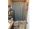 Bathroom featuring a shower with a blue curtain, neutral tones, and a well-lit vanity area at 4855 Mike Ln, Nashville, NC 27856