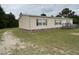 View of a single-story home with tan siding, red shutters, and a grassy yard at 4855 Mike Ln, Nashville, NC 27856