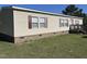 Single-story home with beige siding, red shutters, a brick foundation and a well-maintained lawn at 4855 Mike Ln, Nashville, NC 27856
