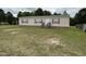 Tan single-story home with red shutters, surrounded by a spacious grassy yard with trees in the background at 4855 Mike Ln, Nashville, NC 27856