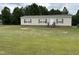 Single-story home with tan siding and red shutters on a large grassy lot with trees in the background at 4855 Mike Ln, Nashville, NC 27856