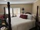 Spacious bedroom with a four-poster bed, white linens, and natural light from large windows at 4855 Mike Ln, Nashville, NC 27856