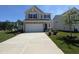 Charming two-story home featuring a two-car garage, stone accents, and a well-manicured front lawn at 521 Morning Light Dr, Angier, NC 27501