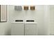 Clean laundry area with a washer, dryer, shelving, storage baskets, and minimalist artwork at 521 Morning Light Dr, Angier, NC 27501