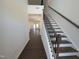 Elegant staircase with dark wood handrail and wrought iron spindles leading to open living space with wood floors at 521 Morning Light Dr, Angier, NC 27501