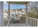 A relaxing balcony offers neighborhood views of townhomes and mature trees creating a serene atmosphere at 521 Village Loop Dr, Apex, NC 27502