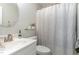 Functional bathroom features a sink, toilet, and shower with a patterned shower curtain, plus decorative accessories at 521 Village Loop Dr, Apex, NC 27502