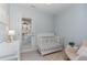 Bedroom features a white crib and changing table, a door leading to an outdoor area, and neutral walls at 521 Village Loop Dr, Apex, NC 27502